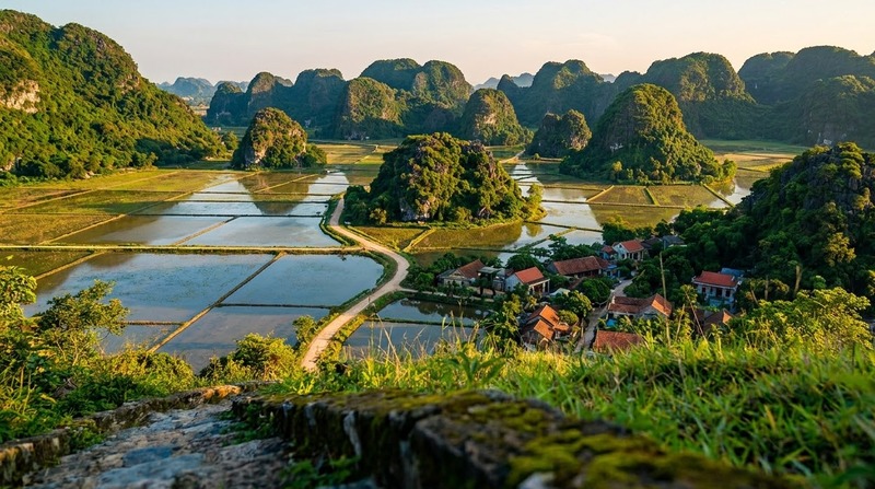 Rounded limestone hills closing around the rice fields of the Hoa Lu basin